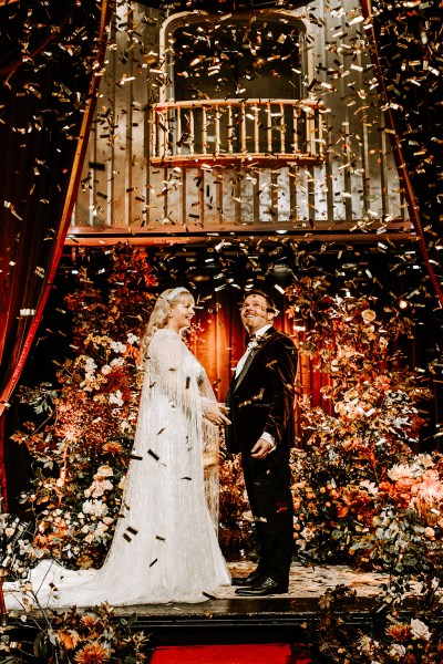 Bride and groom at alter confetti flowers drop on couple