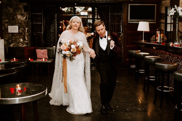 Bride and groom in pub setting link arms