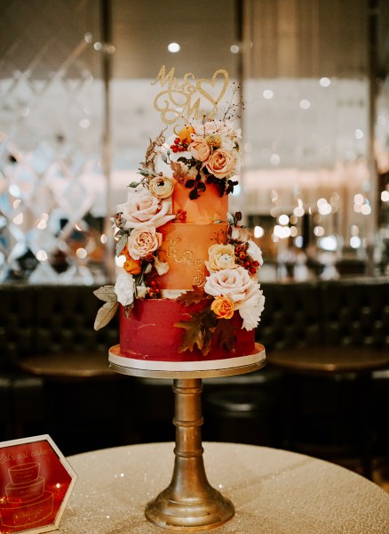 Orange autumnal colours wedding cake flowers on a stilt