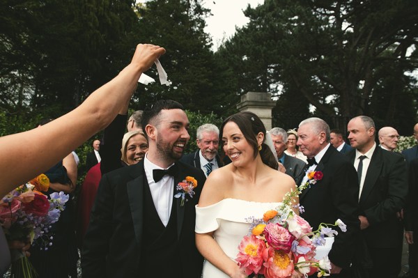 Confetti being thrown over couple by guests bride and groom