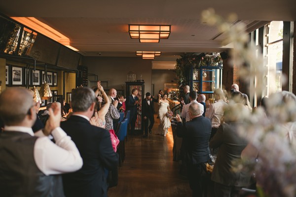 Bride and groom enter ballroom guests clap