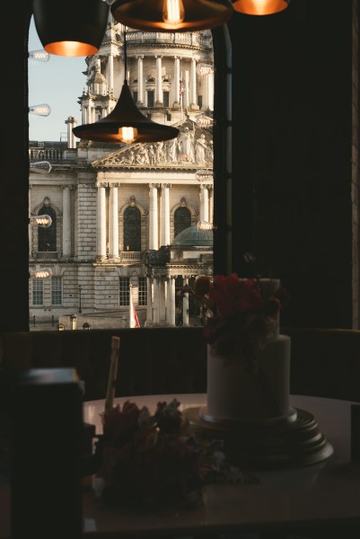 White wedding cake onlooking pillared building in background