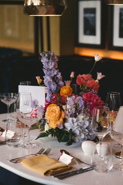 Orange red and pink roses on table