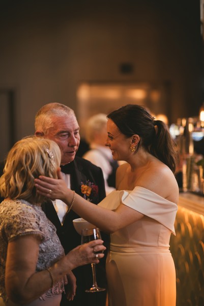 Bride and mother and father chat amongst each other