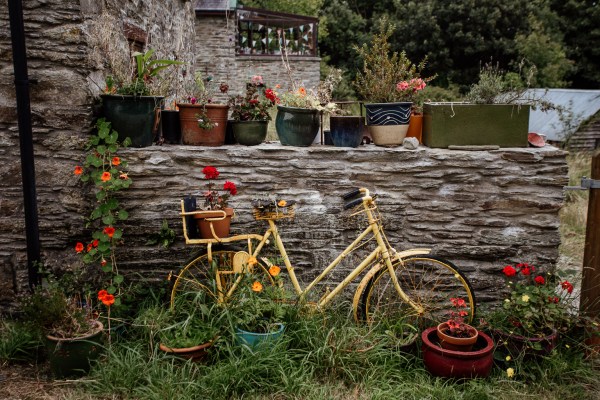 Yellow bike bicycle leaning against brick wall