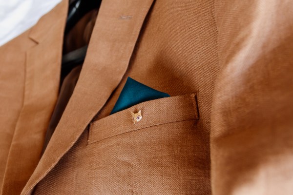 Close up detail of grooms pocket on brown suit