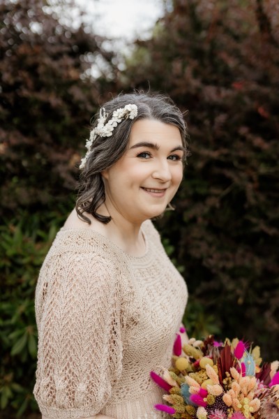 Bride stands holding bouquet flowers