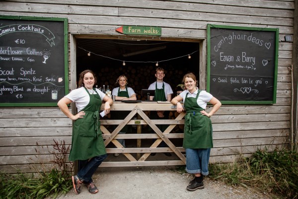 Staff members pose in front of fence smiling