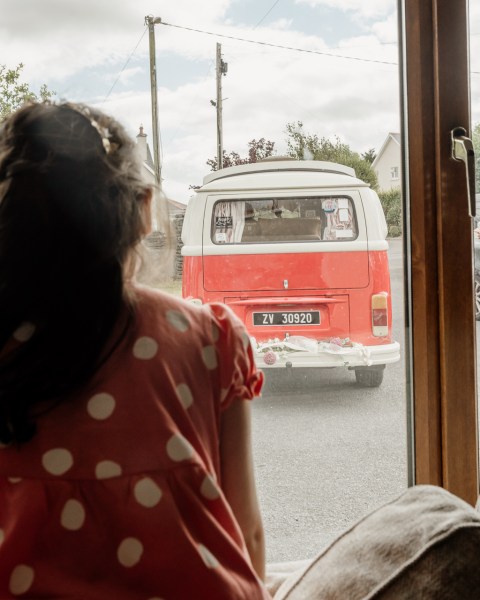 Little girl looks out the window at wedding wagon van car