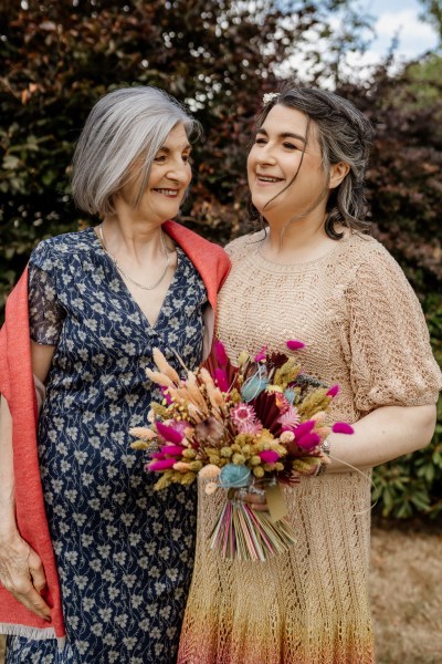 Mother and bride pose and laugh together