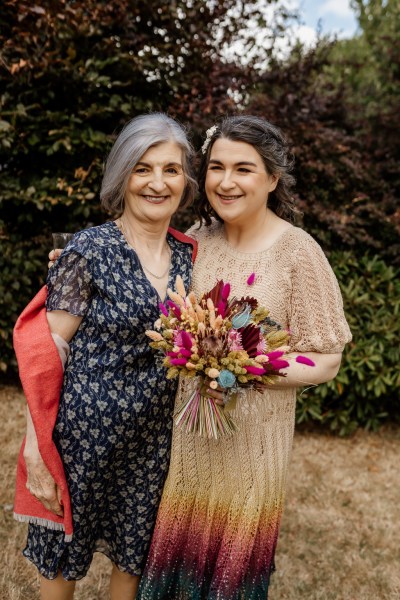 Mother and bride pose and laugh together