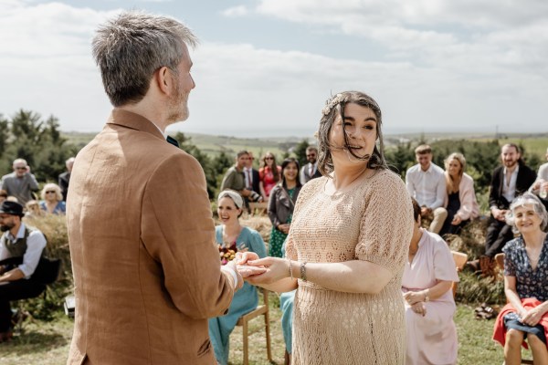 Bride looks over her shoulder as she holds grooms hands