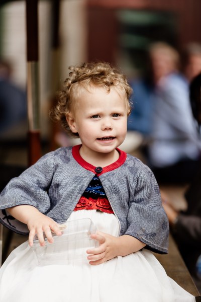 Little girl in grey cardigan smiles for the camera