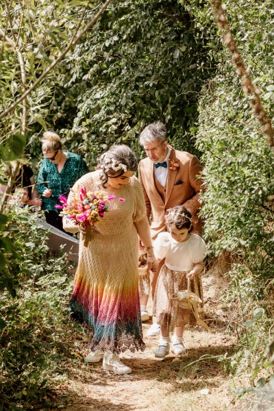 Bride walks with daughter little girl uphill