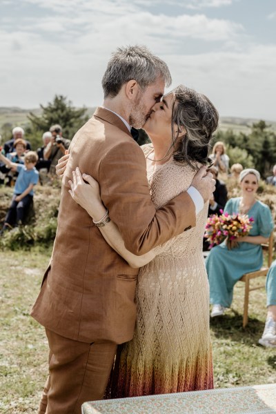 Bride and groom kiss at alter