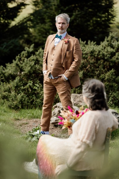 Bride sits in front of groom standing