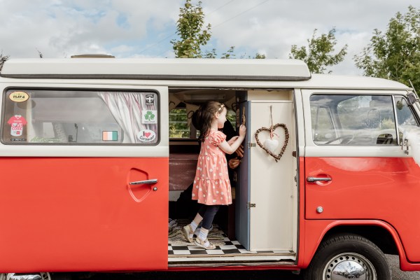 Little girl in wedding wagon car loveheart shaped decoration hangs inside