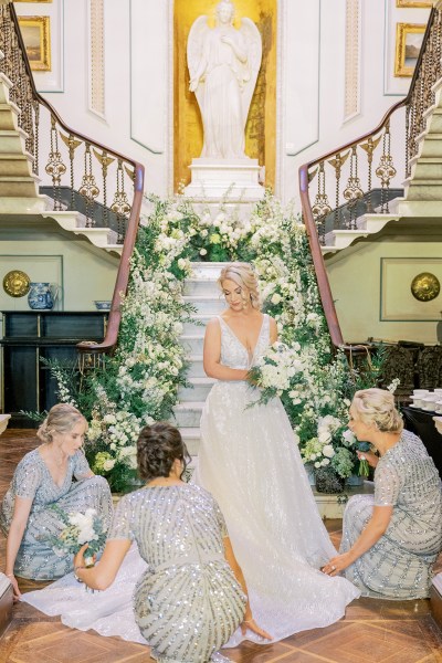 Bride and bridesmaids helping her with her dress