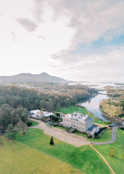 Drone footage of venue from above lake mountains and trees in shot