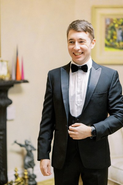 Groom in bowtie and black suit is ready