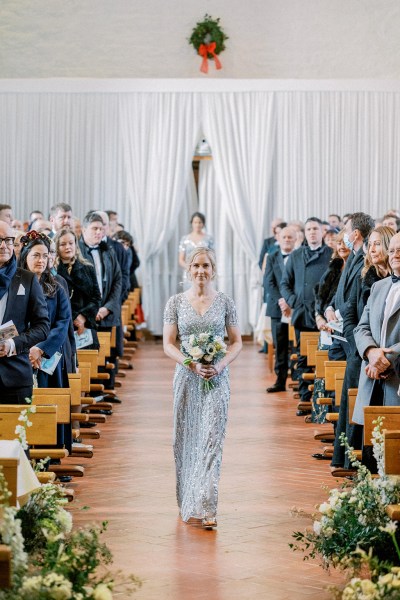 One of the bridesmaids walks down the aisle