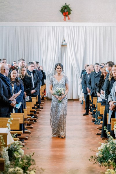 One of the bridesmaids walks down the aisle