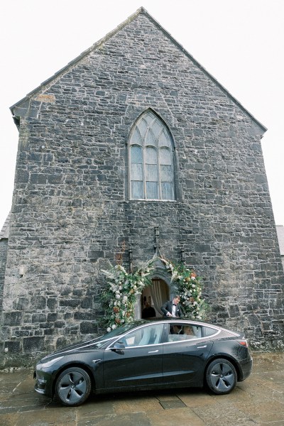 Black car parked outside of church cathedral