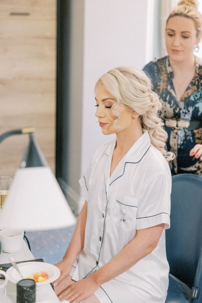 Bride is getting her hair styled by hairstylist