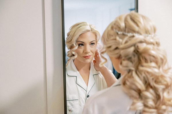 Bride looks at her reflection in mirror