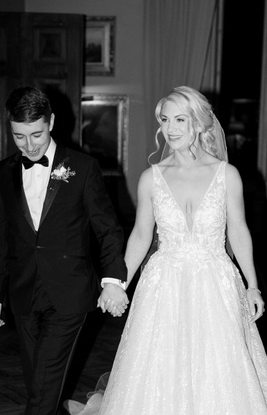 Black and white image of bride and groom holding hands