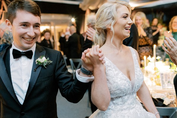 Bride and groom hold hands