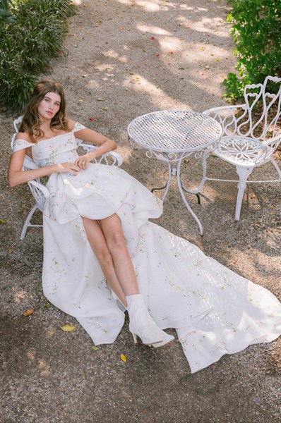 Monique Lhuillier Spring 2024 Collection bride sitting on chair in garden