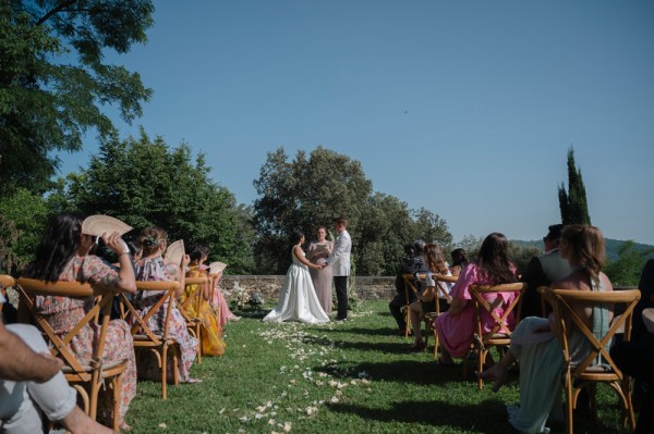 Bride and groom stand at alter with celebrant guests in shot