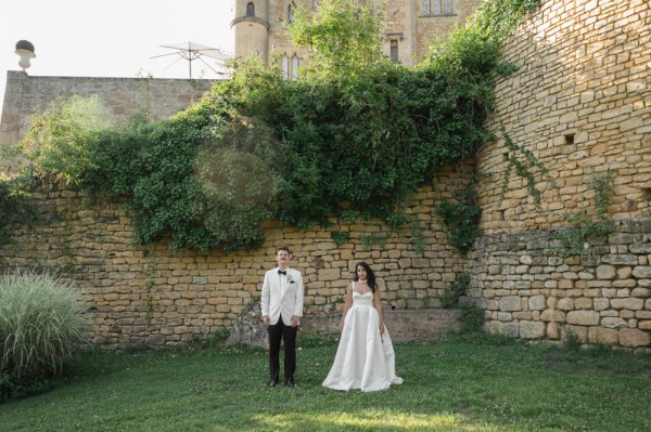 Couple stand on the grass castle venue in background