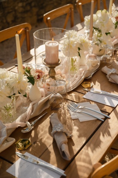 Empty table setting for guests wooden chairs and table candles and flowers