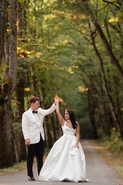 Bride and groom in forest spinning and dancing couple