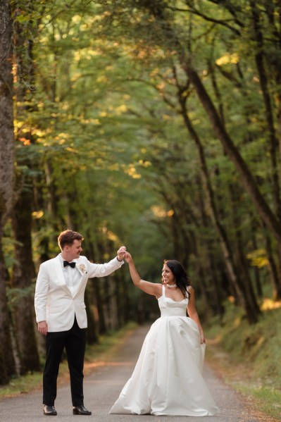 Bride and groom in forest spinning and dancing couple