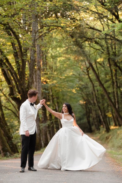 Bride and groom in forest spinning and dancing couple