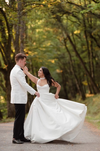 Bride and groom in forest spinning and dancing couple