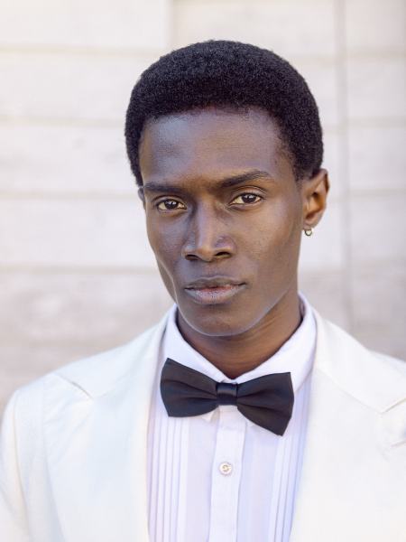 Groom poses in bowtie suit