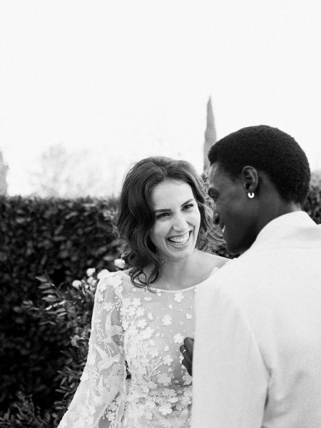 Bride looks at groom laughing smiling black and white