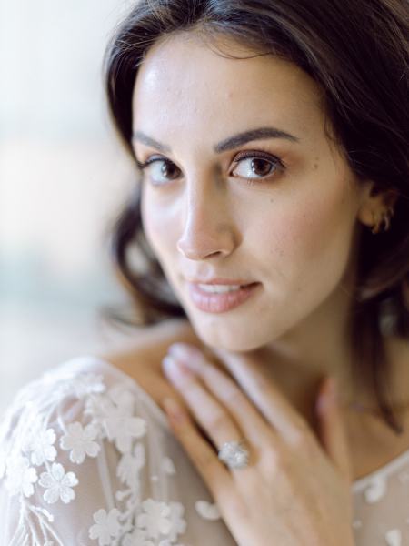 Bride faces the camera and places hand on neck