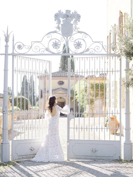 Bride stands under large gates area