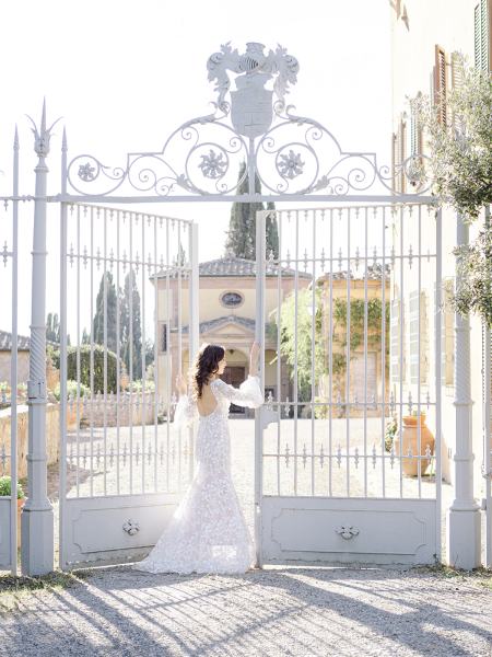 Bride stands under large gates area