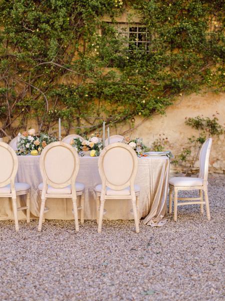 Wedding ceremony setting flowers table and chairs bricked wall