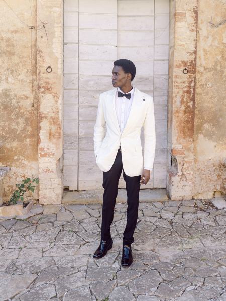 Groom stands on his own hand in pocket white bowtie suit