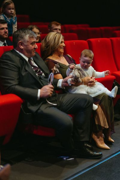 Mother father and little baby girl smiling in red seats