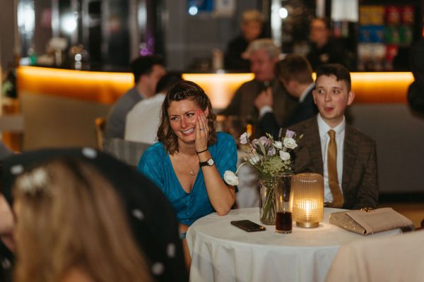 Audience guests members smiling at dining room cinema table