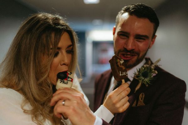 Bride and groom enjoying the chocolate lollipops they laugh and eat them