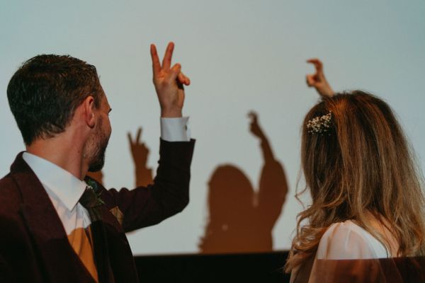 Bride and groom reflection shadows on white cinema screen